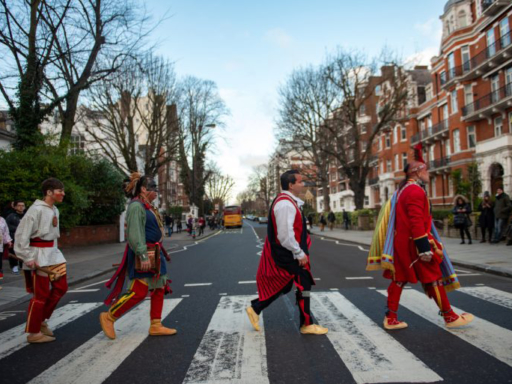 Colour photograph of traditionally dressed native Americans on a zebra crossing