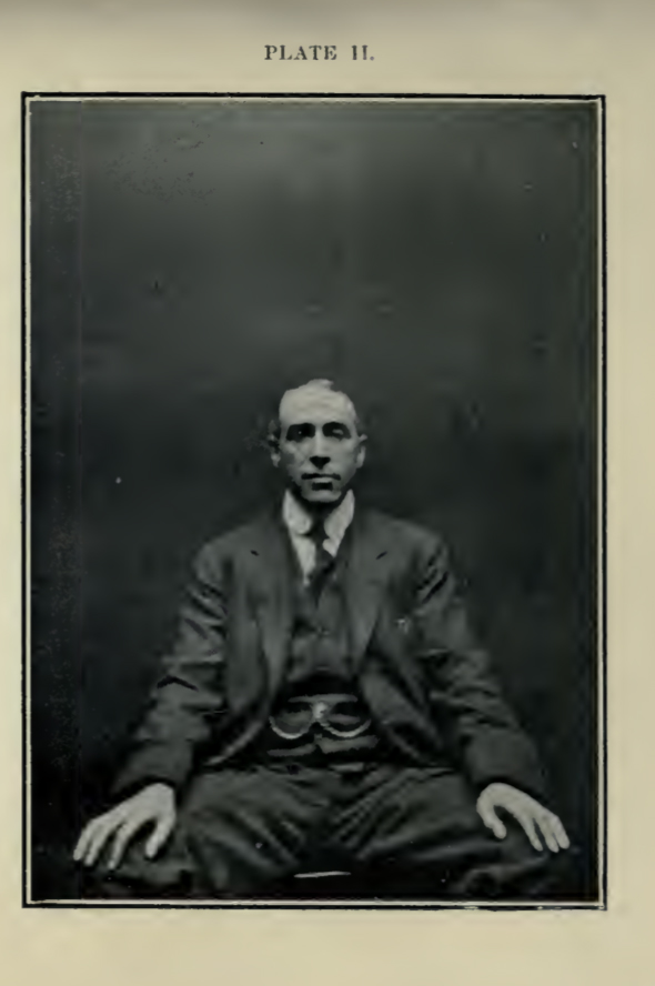 Black and white portrait photograph of a seated Harry Price