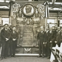 Black and white photograph of a delegation alongside their bronze plaque in honour of George Stephenson