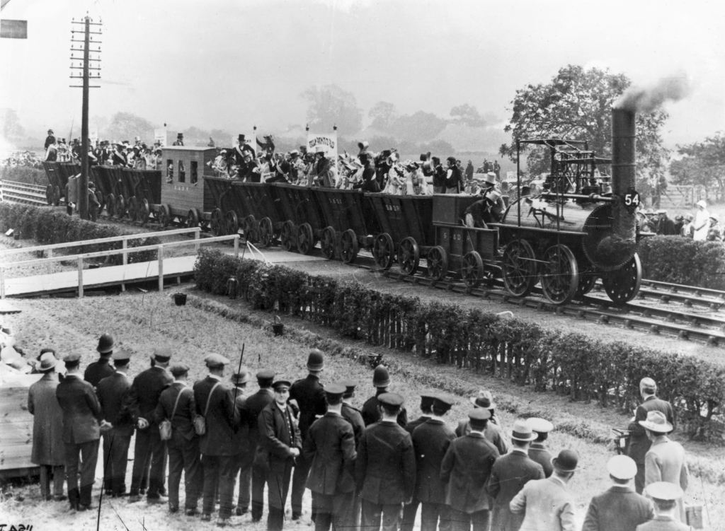 Black and white photograph of Locomotion Number One hauling a replica train in 1925