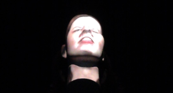 Colour photograph of an audio visual display showing a disembodied talking head