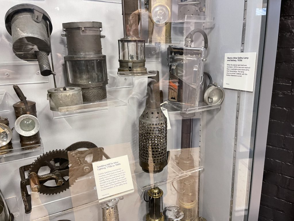 Colour photographs of coal miners safety lamps on display in a museum exhibition