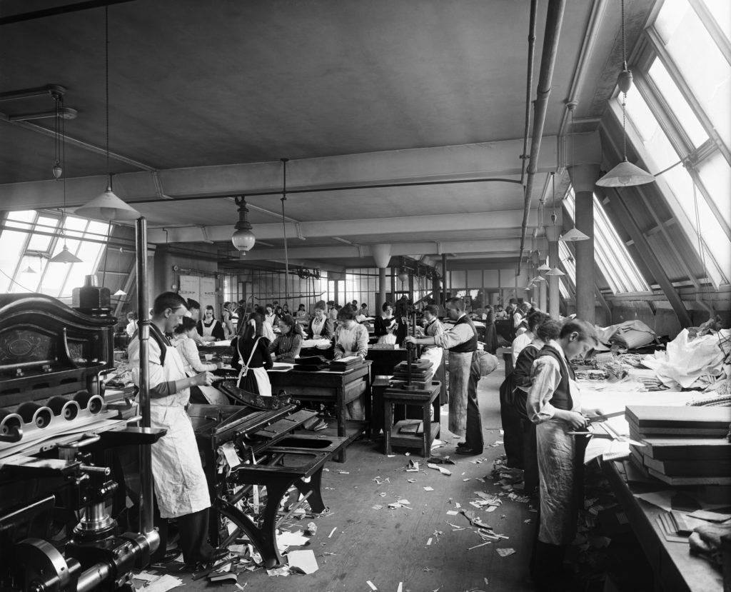 Black and white photograph of workers in a pattern printing and cutting room