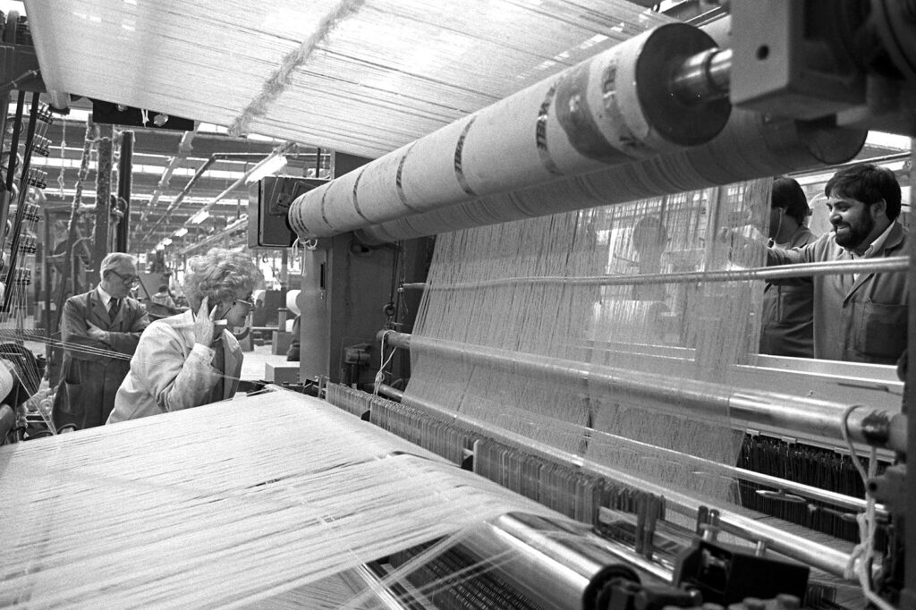 Photograph of workers setting up a loom in the weaving department at Listers Manningham Mill in 1989