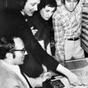 Black and white photograph with several musicians looking at the Synthi 100