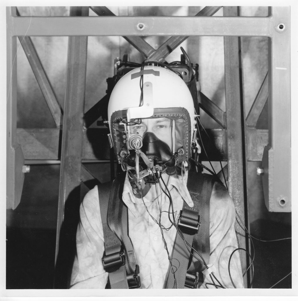 Black and white photograph of Phil Catling wearing equipment to test eye tracking ability under vibration in 1975