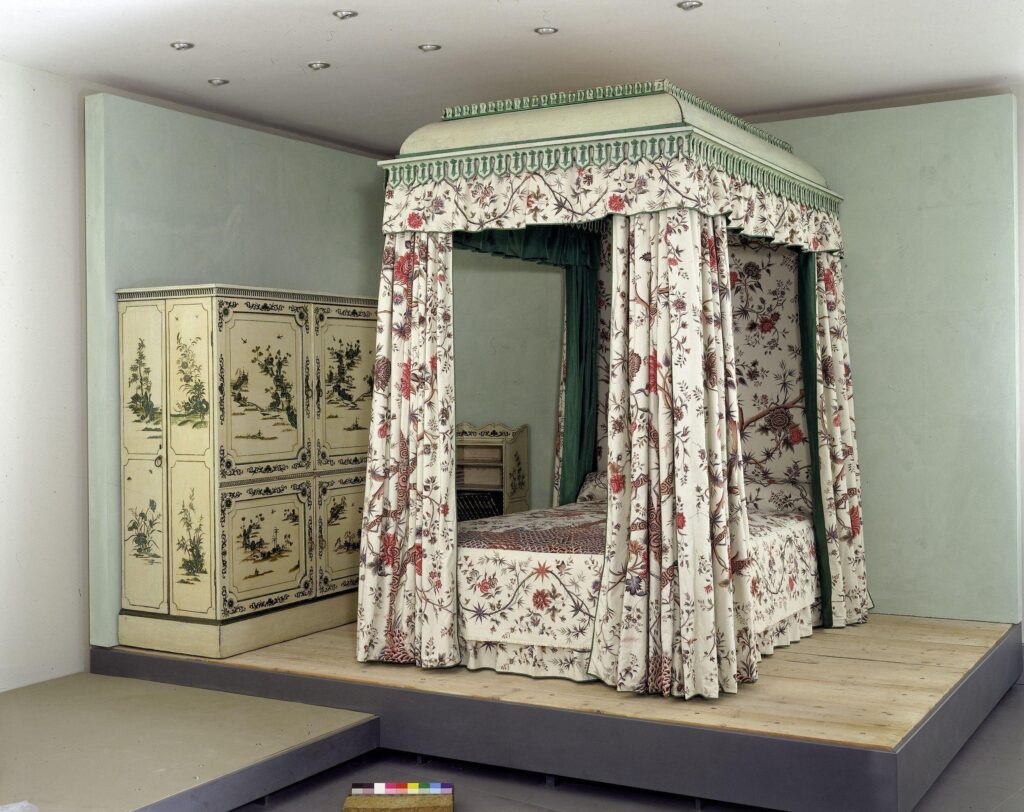 Colour photograph of the Garrick Bed with Indian chintz on display in a museum