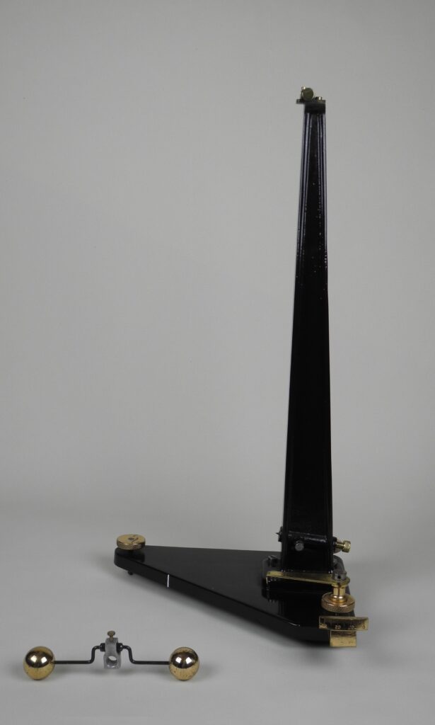 Photograph of an iron column with a triangular base for suspending a pendulum