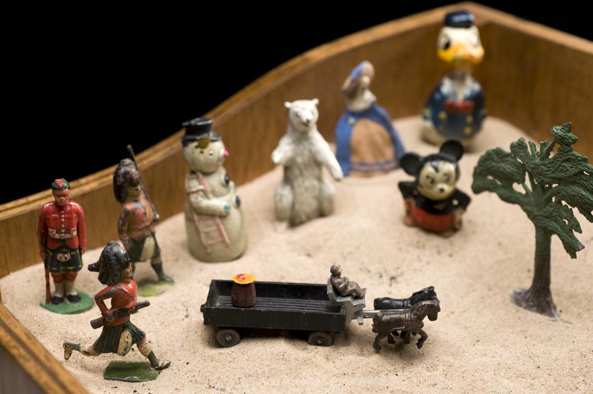 Colour photograph of childrens toys in a sandbox