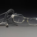 Photograph of a pair of spectacles with attached cheek movement sensor