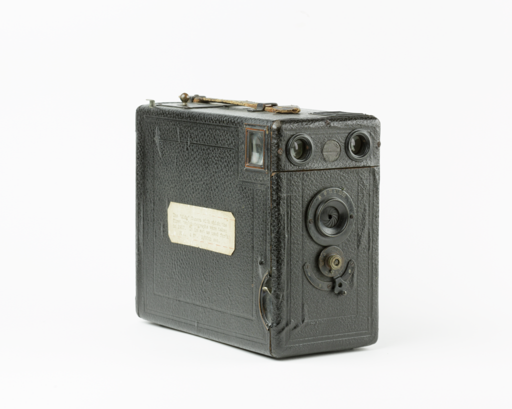 A camera that is almost entirely rectangular, with a handle on the top for carrying. Set against a white background.