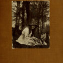 Image of cover of the book 'The Coming of the Fairies' by Sir Arthur Conan Doyle, featuring a photograph of a young girl in a white dress and a hat playing with a gnome outdoors.