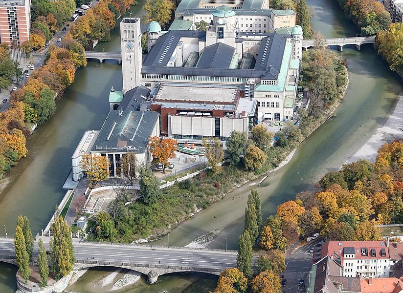 Museum from above, with river Isar on both sides. The surrounding trees are autumnal.