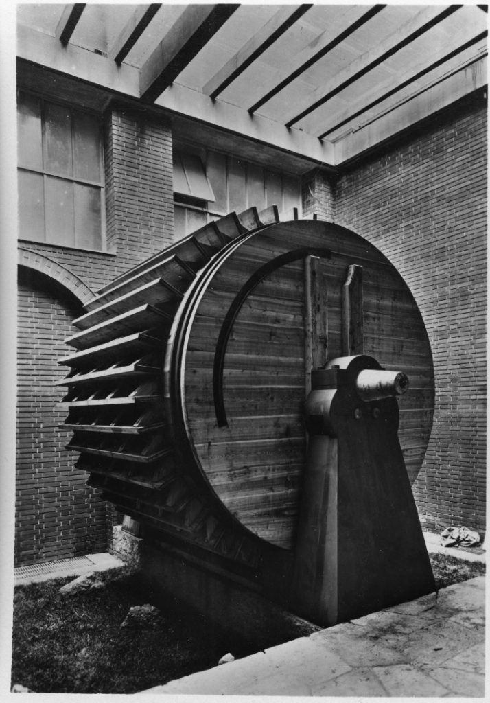 Black and white photograph of a large wooden model of a hydraulic ventilator