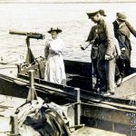 Black and white photograph of Blanche Thornycroft standing in the prow of a pre first world war boat