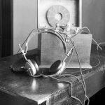 Black and white photograph of an early audio listening device with attached headphones