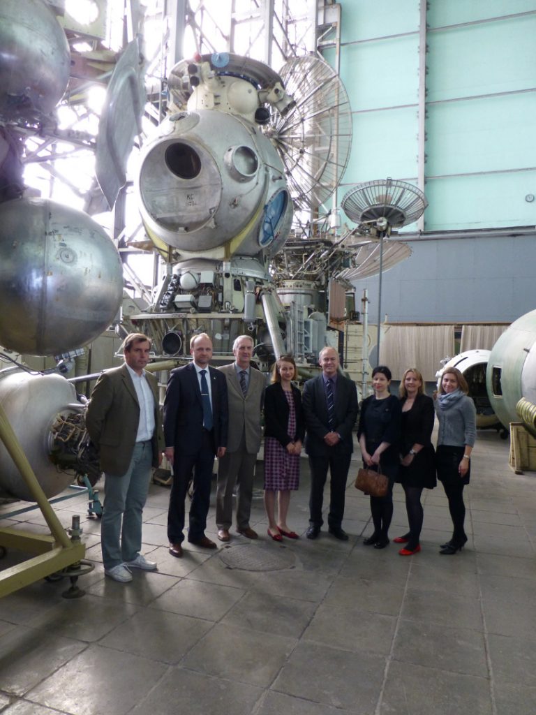 Colour photograph of the Science Museum delegation inside a storage warehouse for old soviet space exploration technology