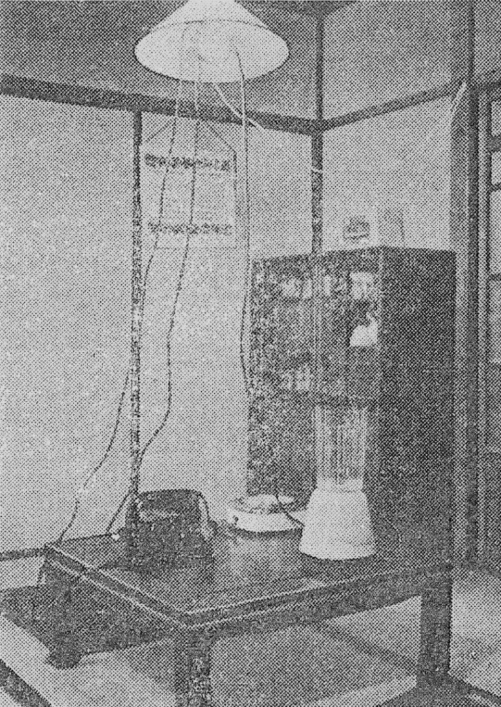 Black and white photograph of a Japanese living room with electricity cables connecting from the light fitting to various electrical devices