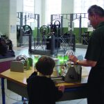 Colour photograph of museum goers using experimentation devices within a museum exhibition on energy