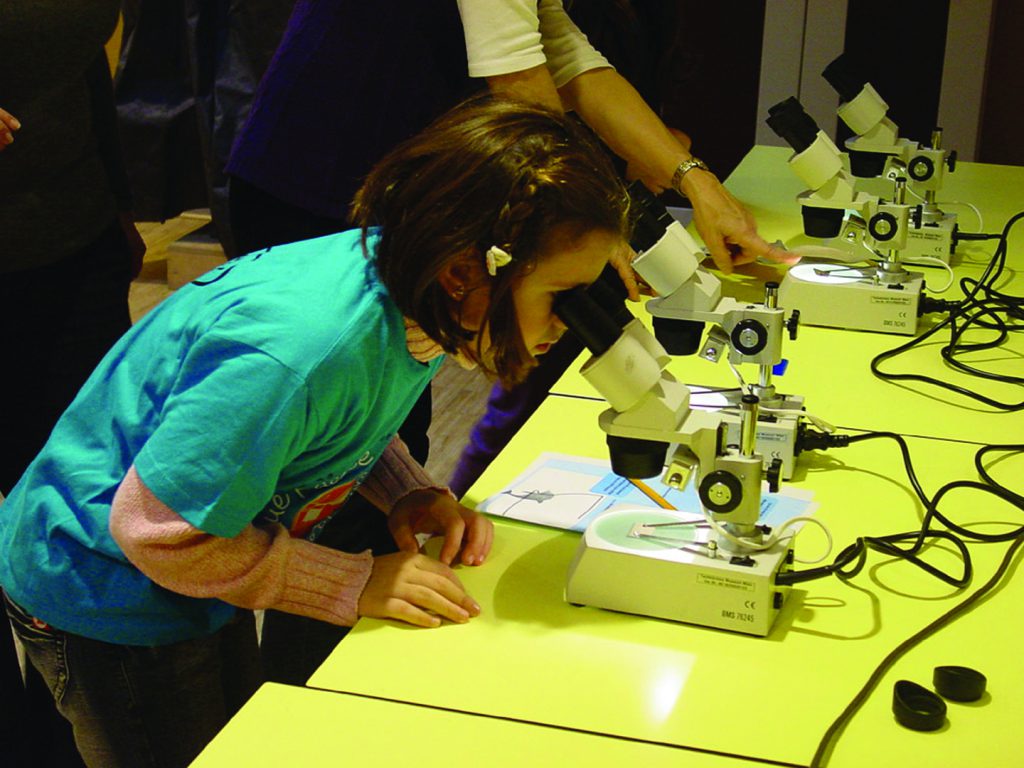 Colour photograph of a young girl using a microscope