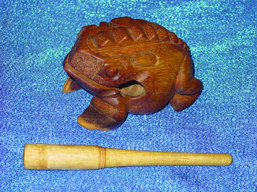 Colour photograph of an historic wooden percussion instrument in the shape of a frog