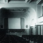 Black and white photograph of the interior of a large auditorium within a technical museum