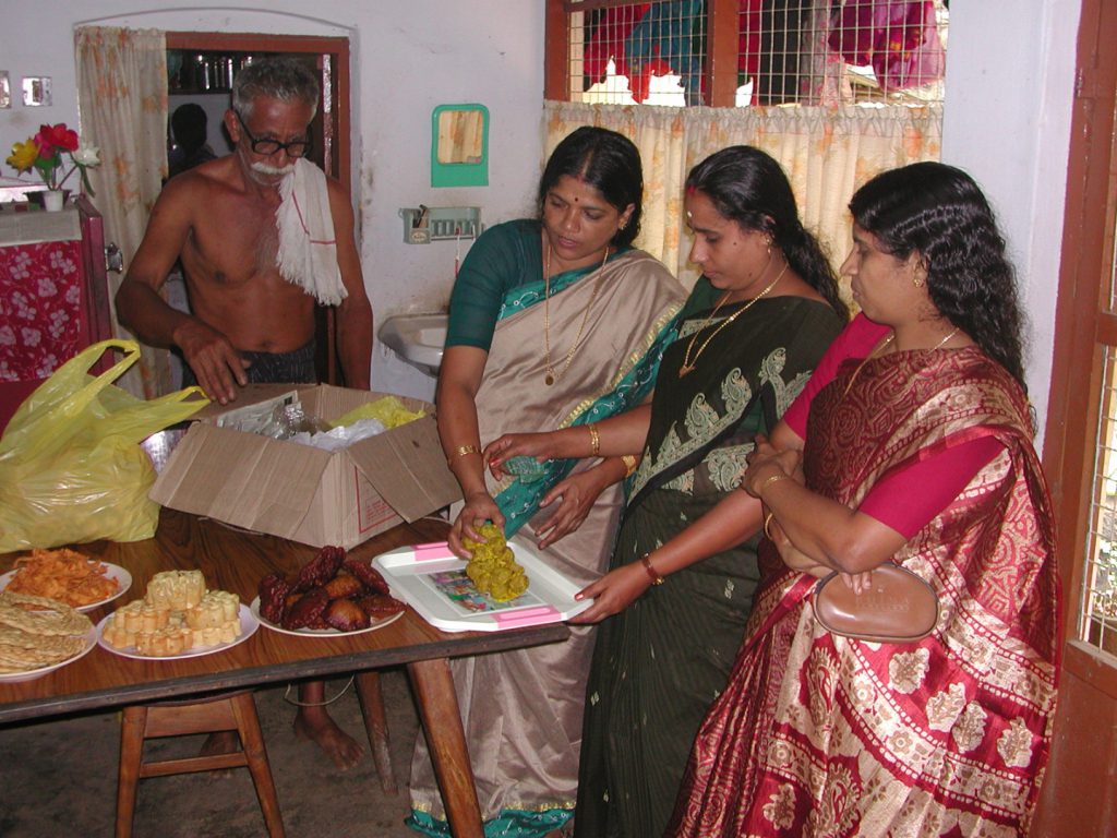Colour photograph of indian women preparing to serve food in a kitchen