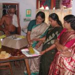Colour photograph of indian women preparing to serve food in a kitchen