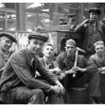 Black and white photograph of a number of male railway workers taking a rest