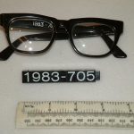 A photograph of a pair of man's spectacles with a black frame