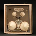 Glass display case containing various nineteenth century cosmetic devices two cheek plumpers eyebrows patches and two breast pads