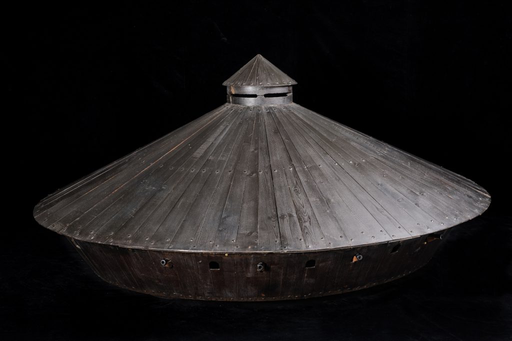 Colour photograph of a wooden model of a covered war chariot