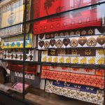 Colour photograph of a museum display case showing different examples of Kanga fabric wraps