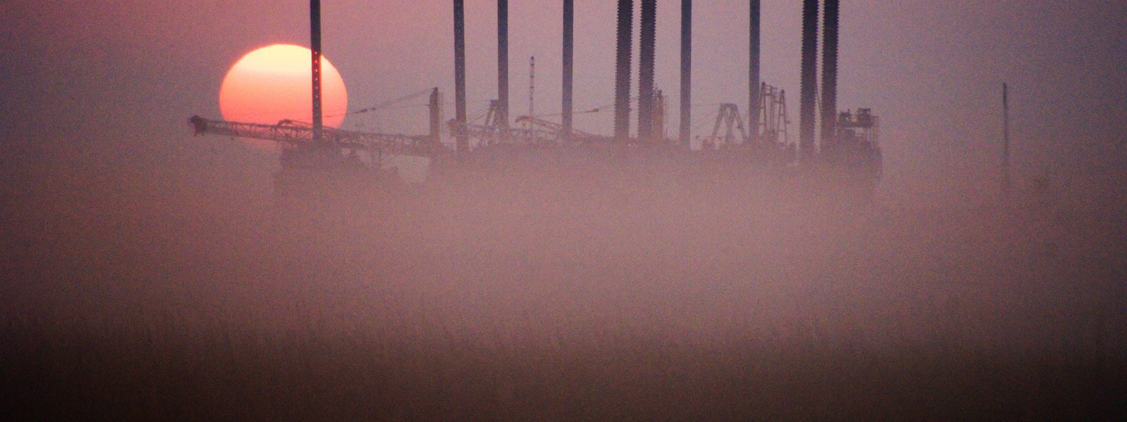 Colour photograph of a sunrise over an oilfield in Texas North America