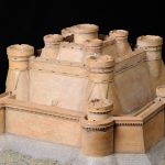 Colour photograph of a painted model of a mountain fortress
