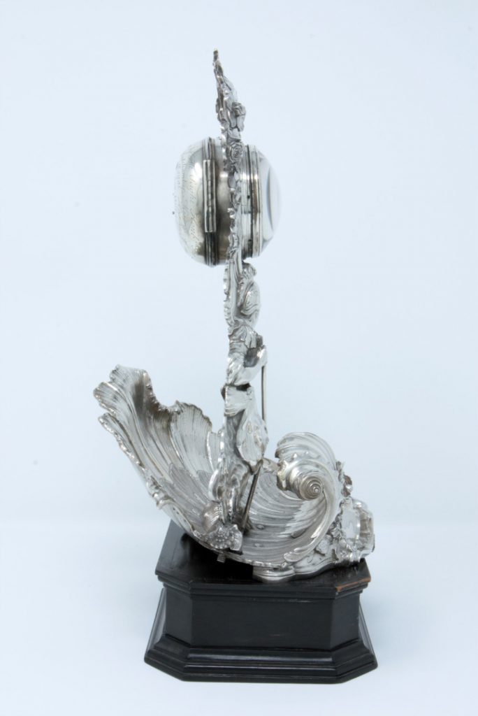 A photograph taken from the side, showing the silver clock