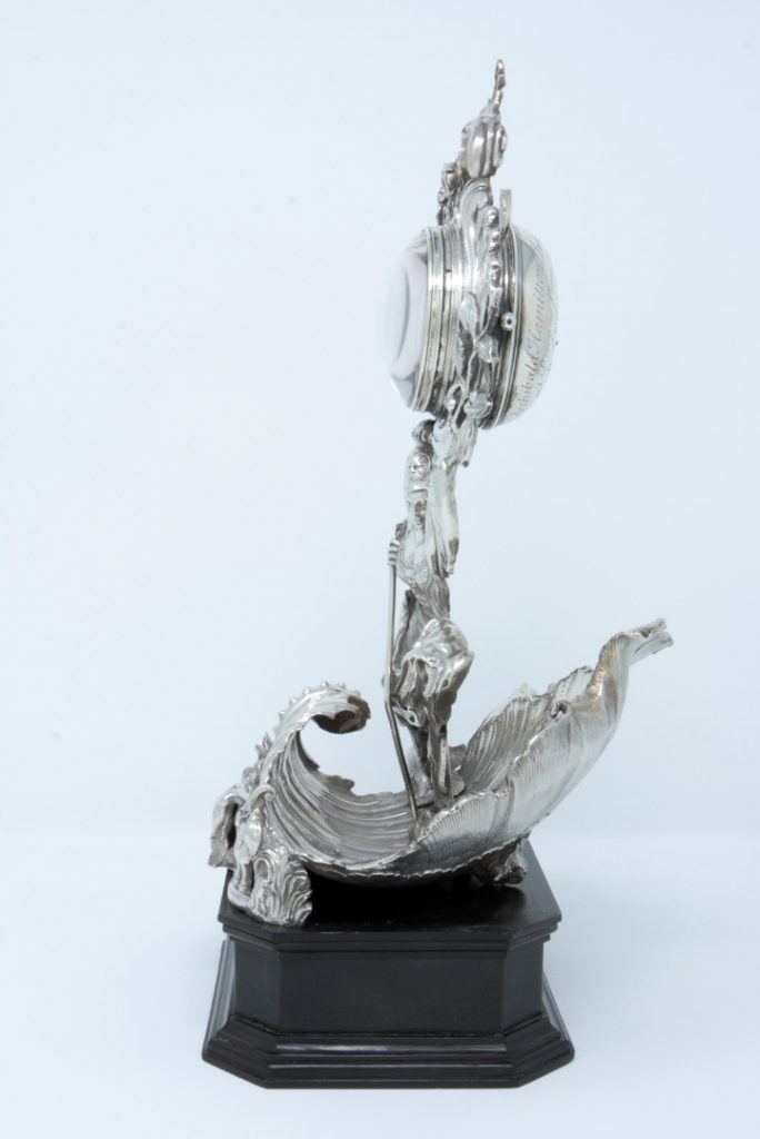 A photograph taken from the side showing the silver clock