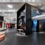 Colour photograph of a section of the Information Age gallery showing a constellation display a public telephone box and an aerial walkway which runs around the perimeter of the exhibition