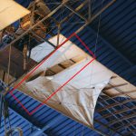 Colour photograph of a large rip in the fabric covering the wing of a JAP Harding Monoplane
