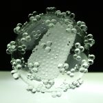 Colour photograph of a large scale glass sculpture of an HIV virus