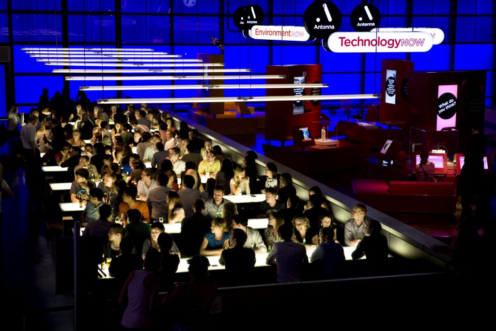 Elevated view photograph of seated adults taking part in a pub quiz during on the of the Science Museum Lates