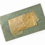 Colour photograph of a dried folded caul with envelope