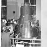 Black and white photograph of a press viewing of the Freedom 7 space capsule