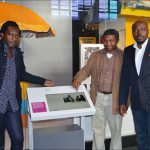 Colour photograph of three particpants from Cameroon in the Information Age gallery