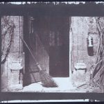 Early black and white photograph by William Henry Fox Talbot of an open door with broom and lantern