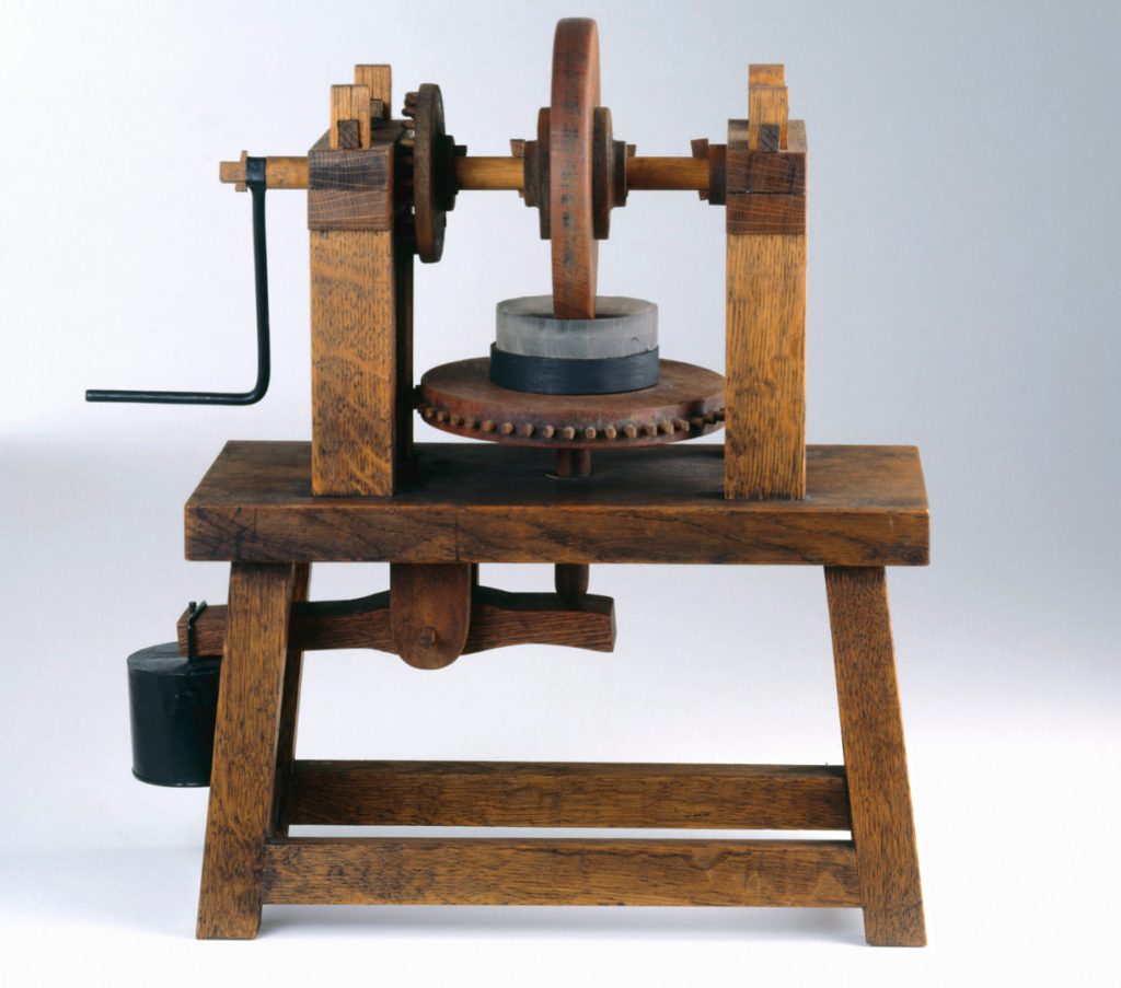 Colour photograph of a working wooden model of a machine for grinding concave mirrors