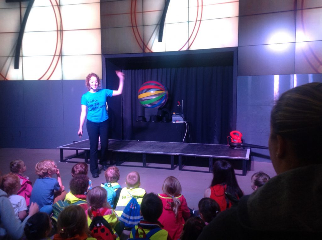 Colour photograph of a science museum explainer giving a demonstration to school children