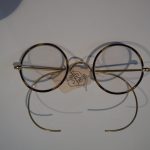 Colour photograph of a pair of Windsor style NHS spectacles with Xylonite covered rims