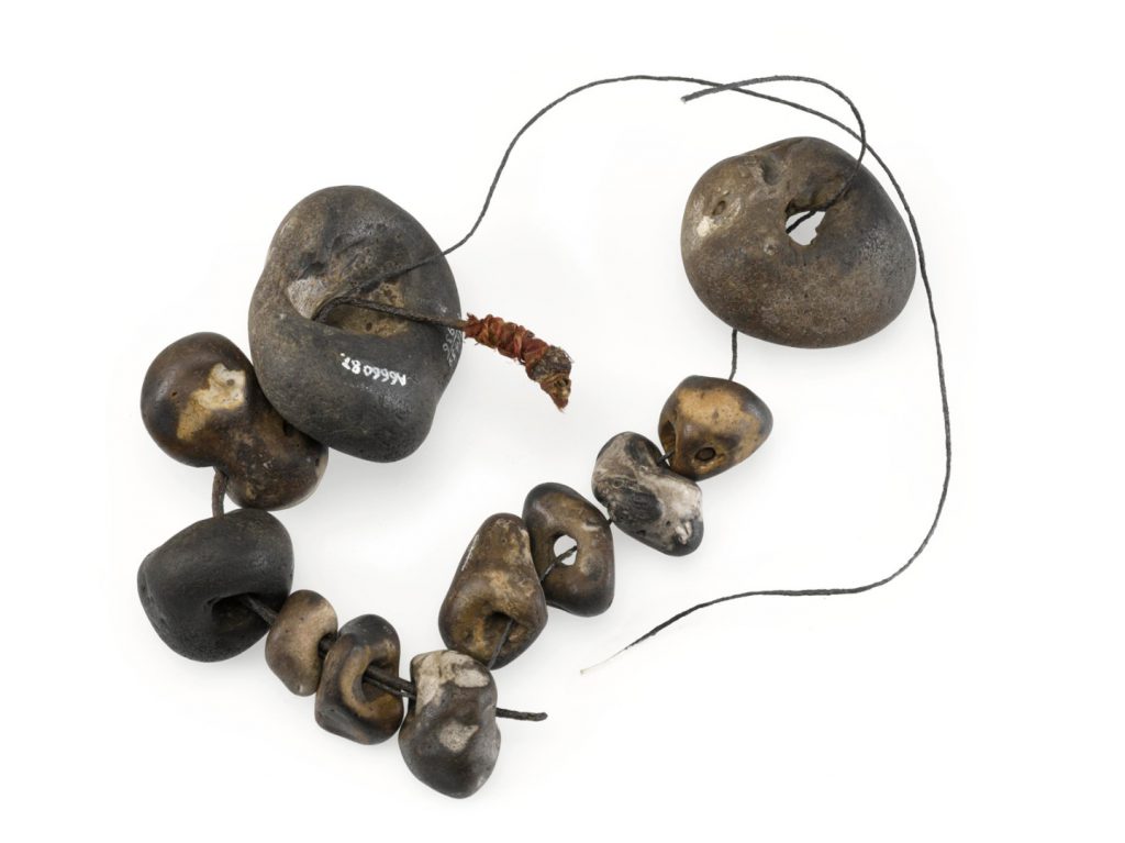 Colour photograph of a number of holed stones threaded onto twine