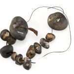 Colour photograph of a number of holed stones threaded onto twine